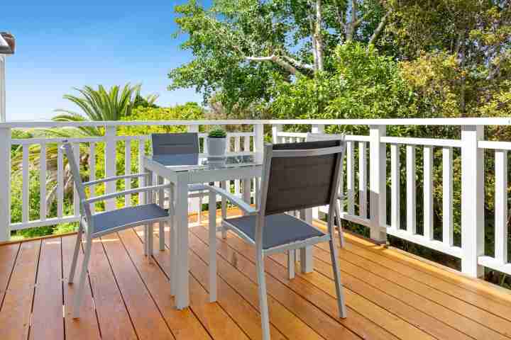 Outdoor seating area on sunny balcony at Eight on Church, family holiday destination on Waiheke Island