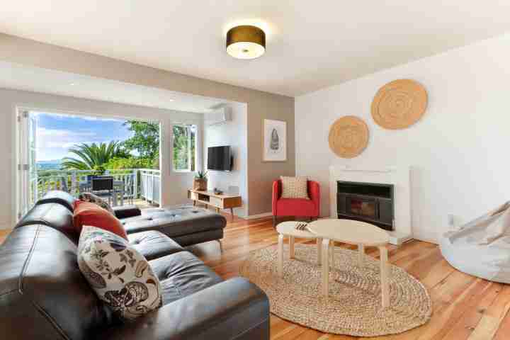 Modern spacious open-plan living area with balcony access at Eight on Church, Waiheke Island