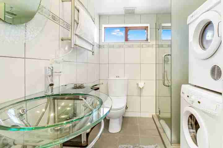 Modern bathroom with laundry facilities including washing machine and dryer
