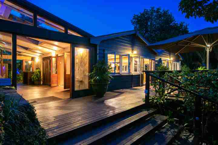 Kauri springs lodge large deck with outdoor seating at night