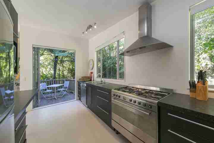 Fully equipped open-plan modern kitchen in Ted's Cottage with outdoor decking